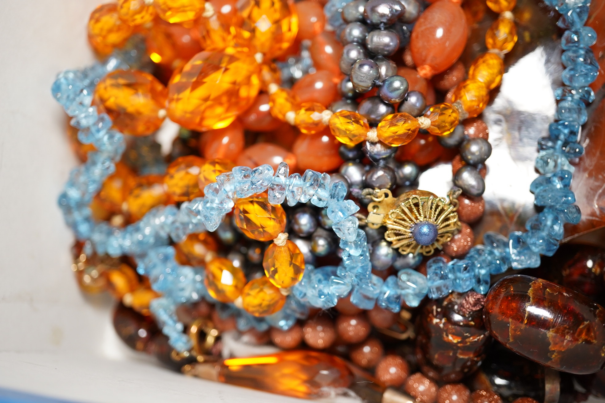 A group of assorted amber and other jewellery including carnelian necklace, glass bead necklace, aquamarine pebble necklace, etc. Condition - fair
